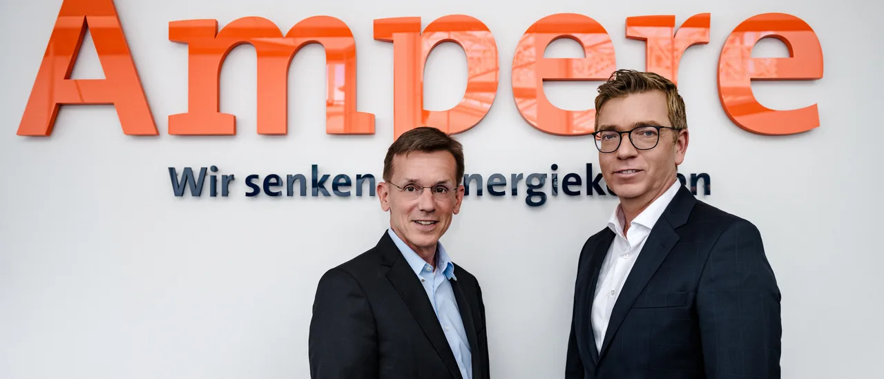 Der Vorstand der Ampere AG vor dem Firmenschriftzug